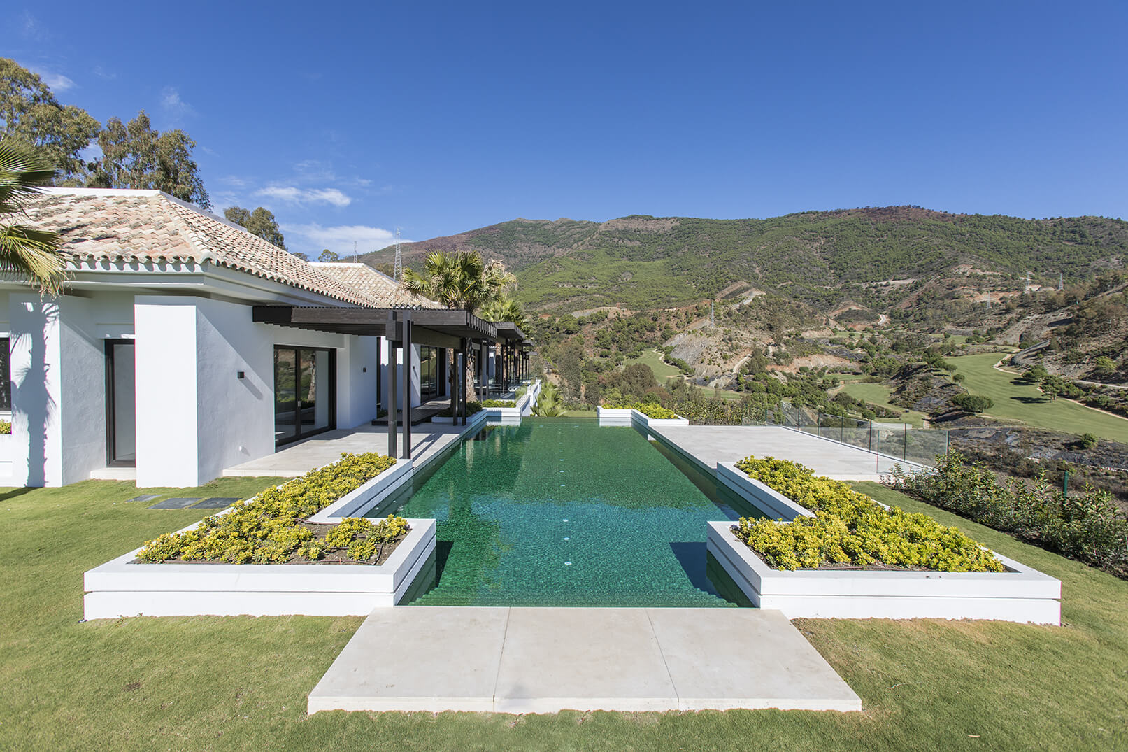 Professional real estate pool photography – luxury villa with infinity pool, manicured garden and panoramic mountain views, Costa del Sol