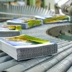 Revistas recién impresas en una cinta transportadora de una imprenta