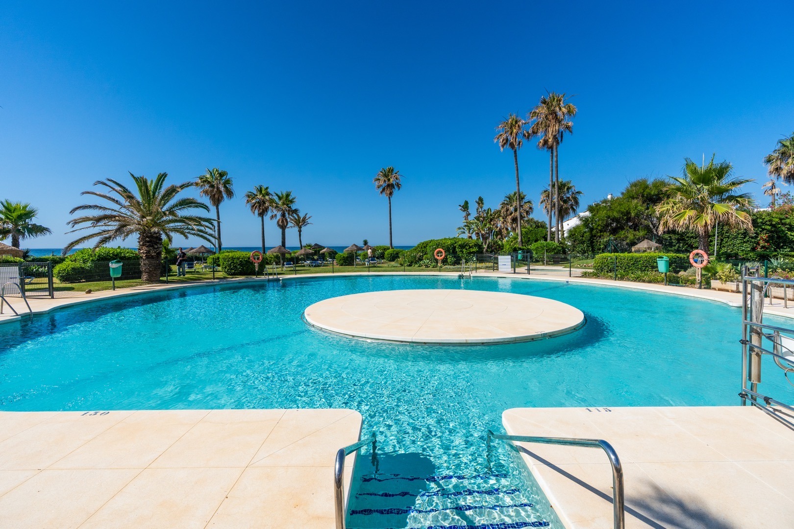Communal pool with palm trees in a Fuengirola development – real estate photography