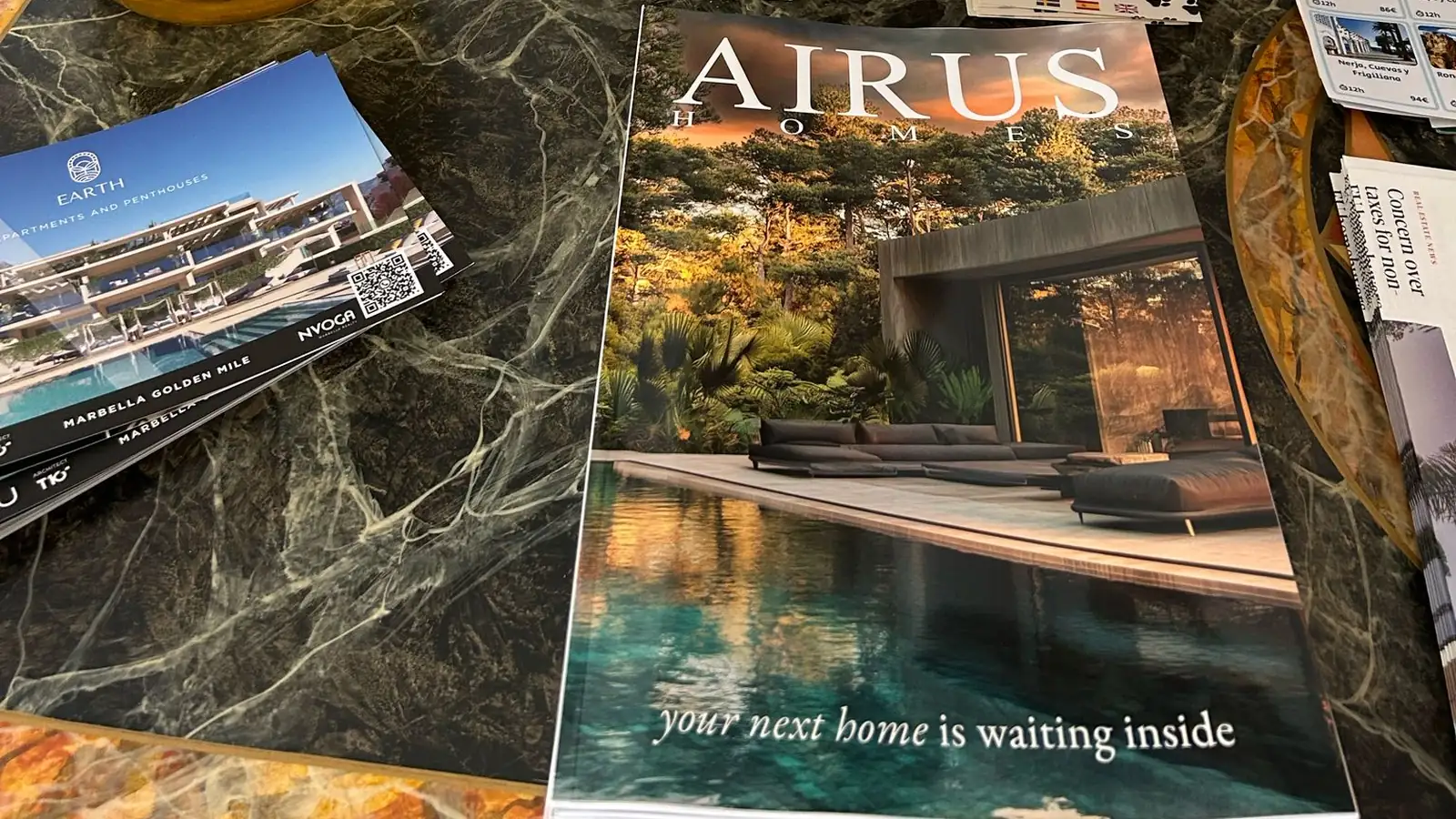 Revista impresa de una inmobiliaria sobre una mesa de mármol en el vestíbulo de un hotel de la Costa del Sol